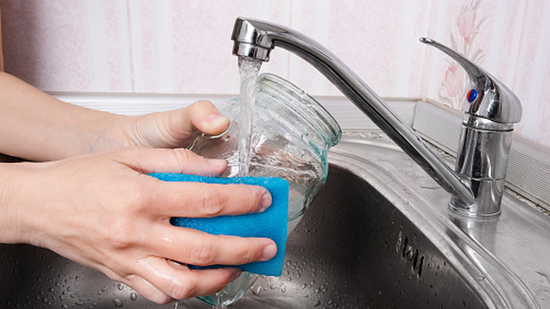Person washing a jar in the sink