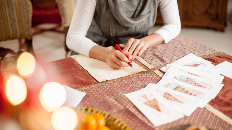 a woman writes Christmas cards