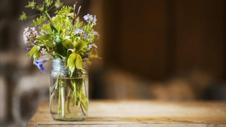 simple floral and greenery arrangement in a glass jar