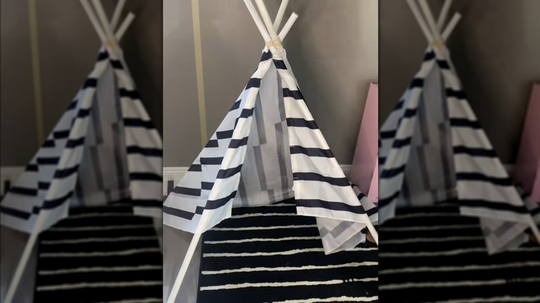 Child play tent made of striped upcycled curtain and sticks