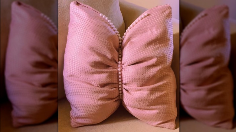 Chic throw pillow with pink shower curtain cover and beaded embellishments on couch