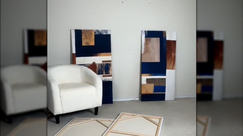 Abstract-style shower curtain canvas art against wall in all white living room