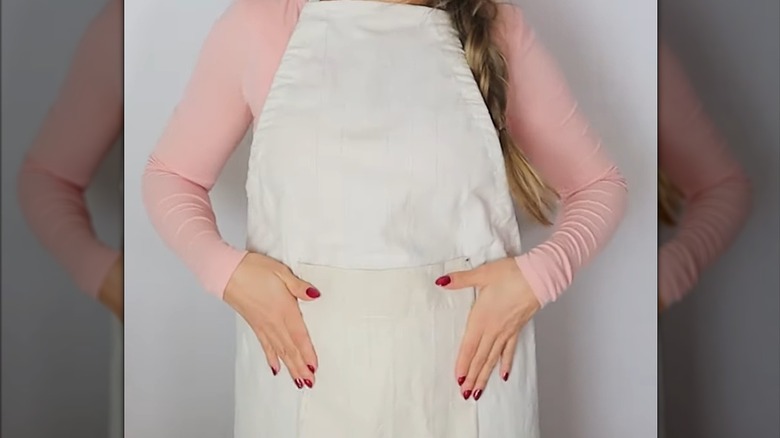Woman with hands resting on DIY shower curtain apron