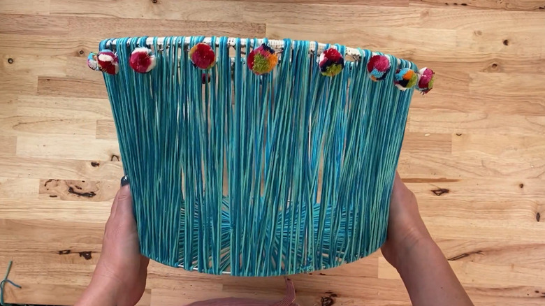 Storage basket made of a tomato cage and yarn