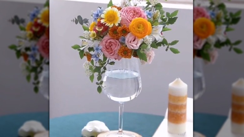A small bouquet of flowers on top of a wine glass
