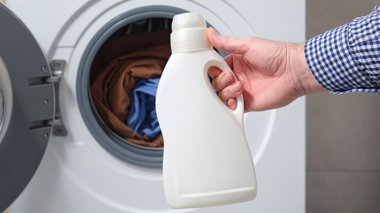Man holding laundry detergent bottle
