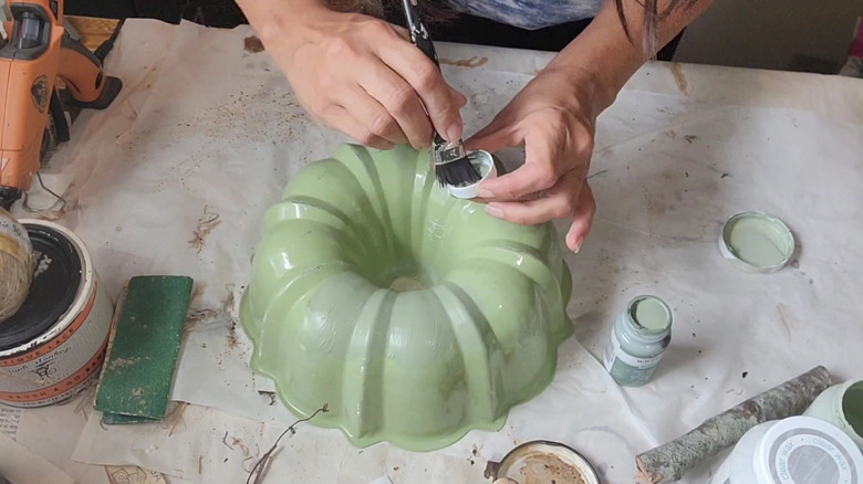 Person painting a Bundt pan for an upcycle project