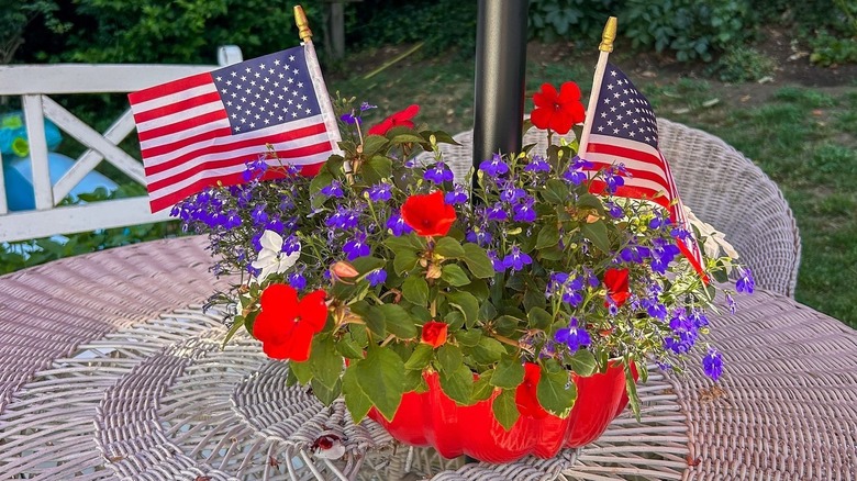 A red Bundt pan turned into a flower planter for a patio table