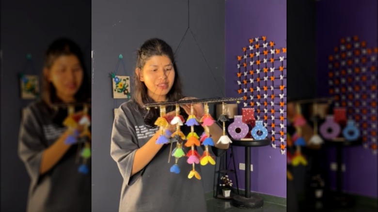 Creator attaching the strands of flowers to the cardboard top