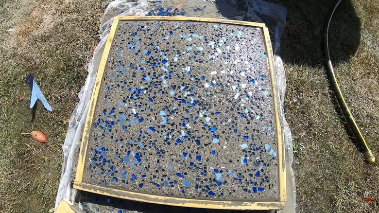 Large square paver with broken glass pieces in them