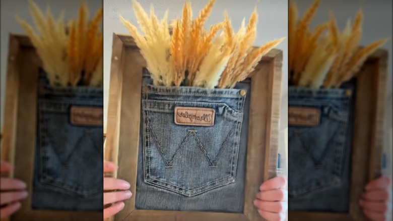 Jean pocket in picture frame filled with fall-like foliage for rustic wall decor