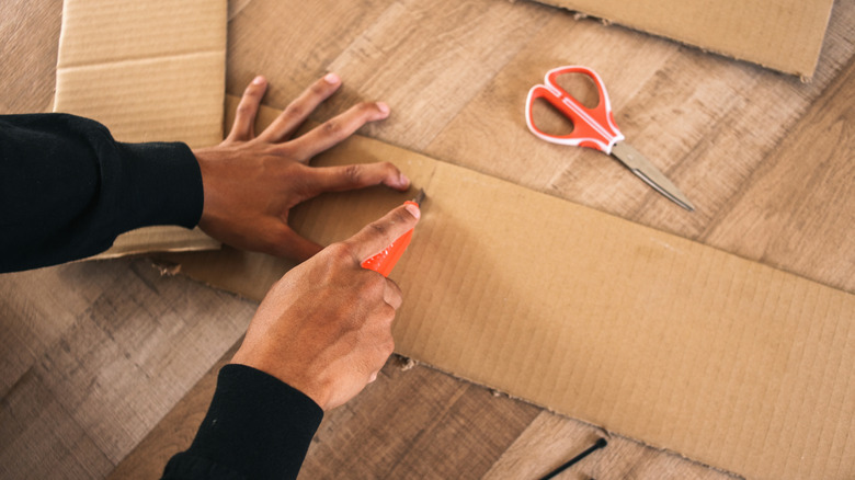 Person making relief cuts in cardboard