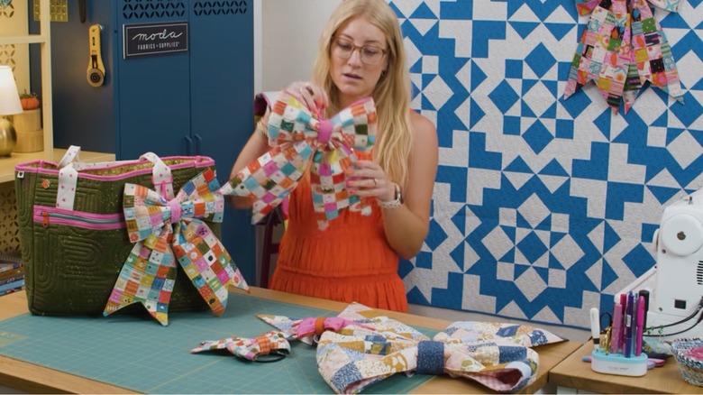 A woman demonstrates fabric quilted bows