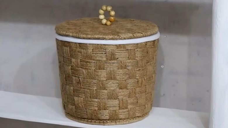 A jute-lined wastebasket made from a plastic canister