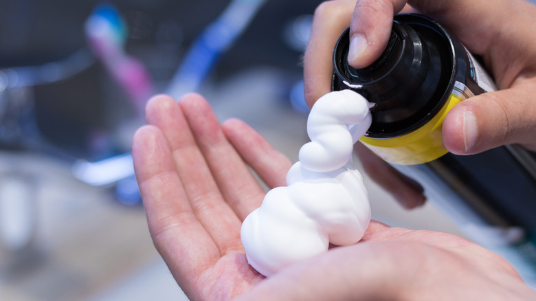 Person applying shaving cream in their hand