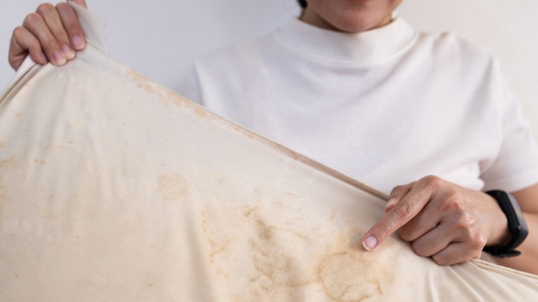 Person holding a stained pillow