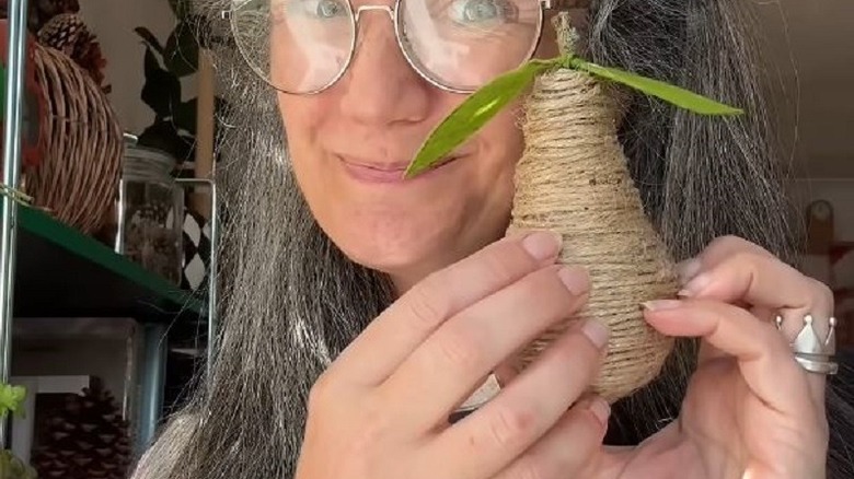 Woman holding lightbulb turned into decorative pear