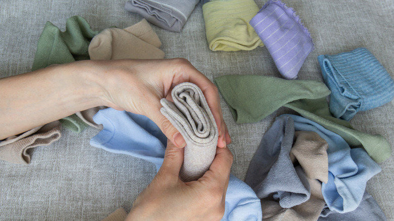 Female hands holding a rolled pair of socks
