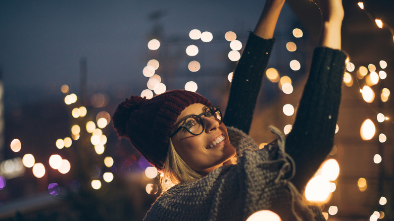 Woman hanging up a set of white string lights