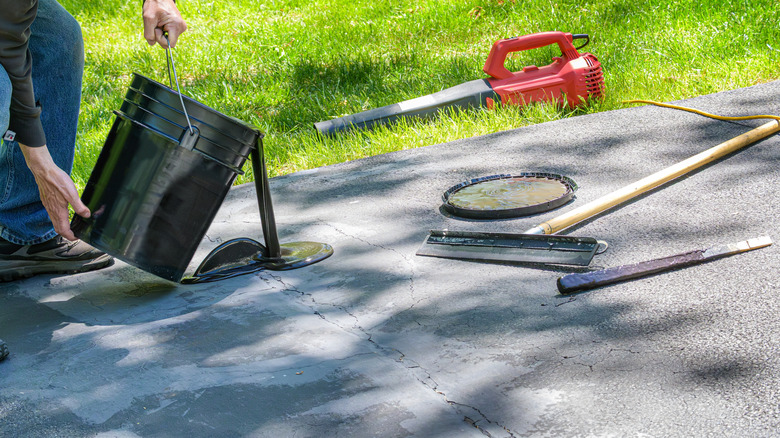 A person repairing cracked asphalt