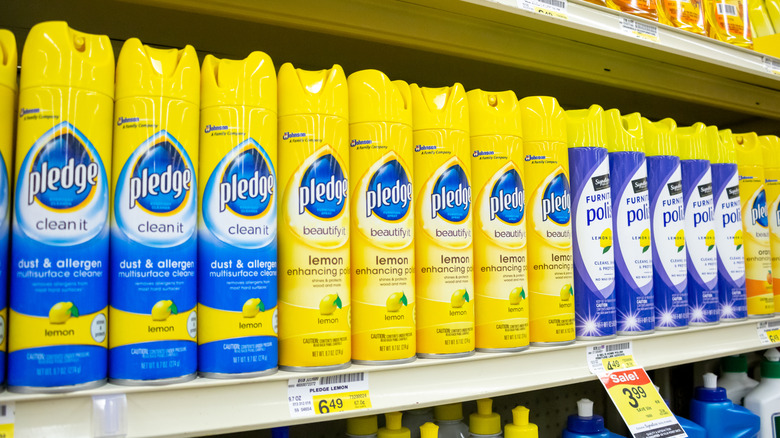 A lineup of Pledge brand cleaning sprays on a grocery shelf.