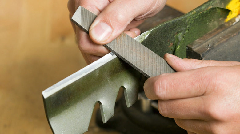 sharpening a lawnmower blade with a file