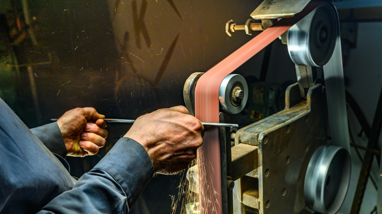 Shaping steel on a belt sander.