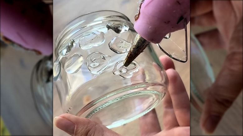 Putting hot glue on glass jar