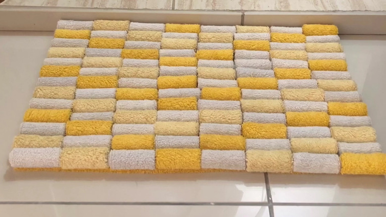 hands gluing towel rolls to DIY bath mat