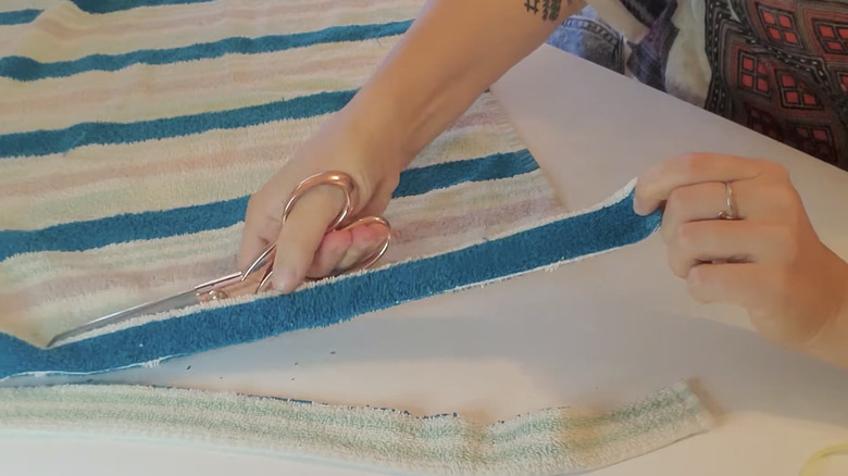 hands cutting towel with scissors