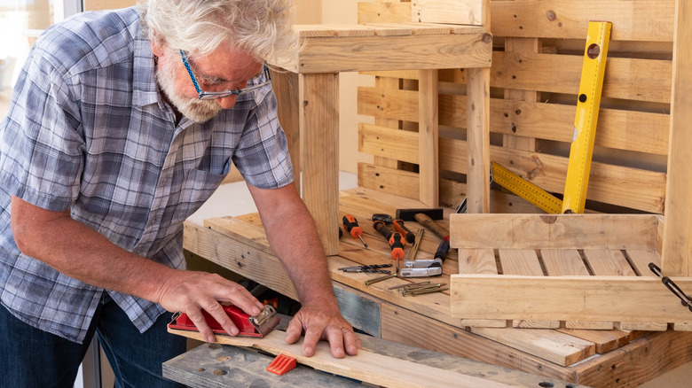 Person sanding wood plank to use on a project