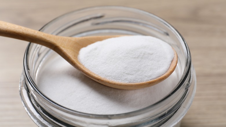 Jar of baking soda with a wooden spoon