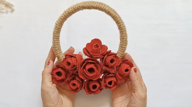 hands holding DIY egg carton flower wreath