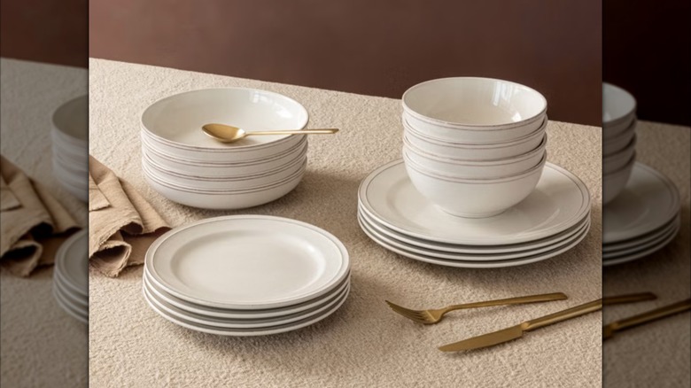 A set of ivory over&back Lake Como dinnerware sits on a tan tablecloth