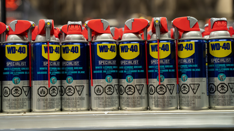 A row of spray cans of WD-40 lined up on a store shelf