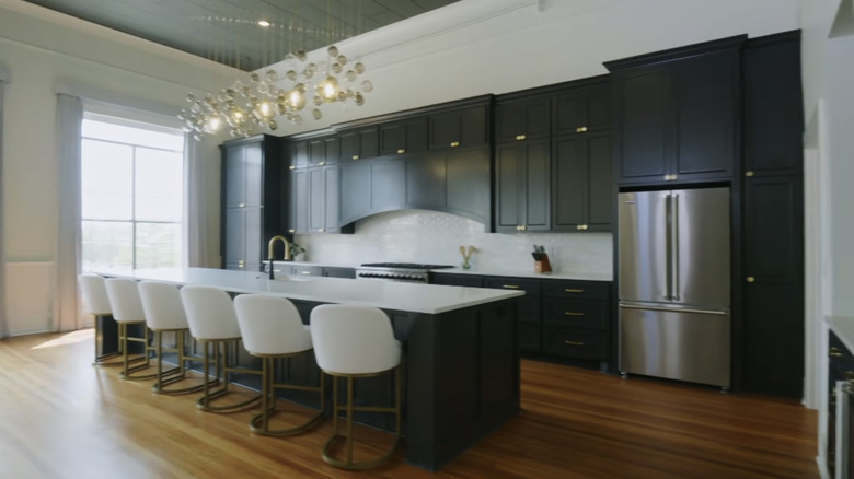 A large open plan kitchen with shaker cabinets painted black