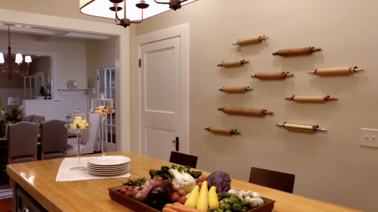 Rolling pins as a statement wall in a white kitchen with an island