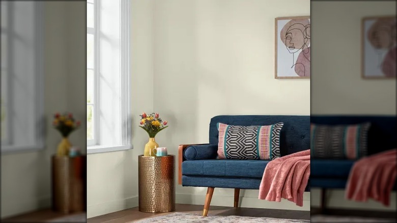 A living room painted in Brown Buzz with a dark blue sofa
