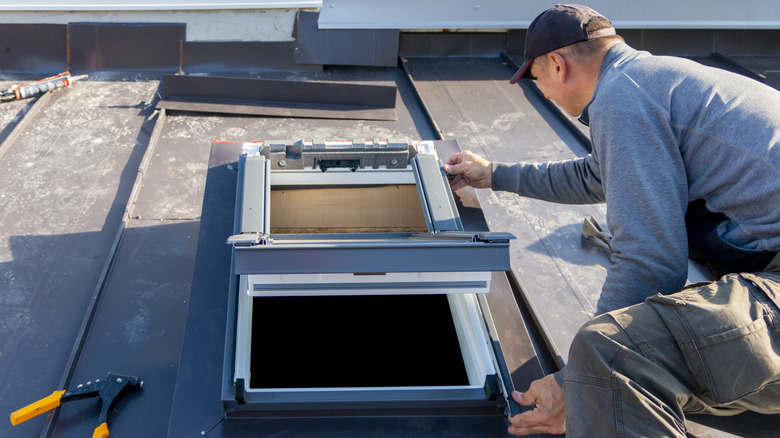 a man applies flashing to a skylight