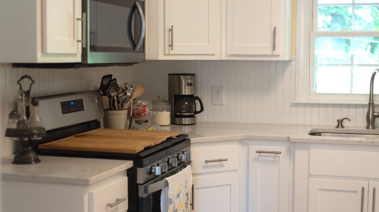 Beadboard wainscoting used as a backsplash in a white kitchen
