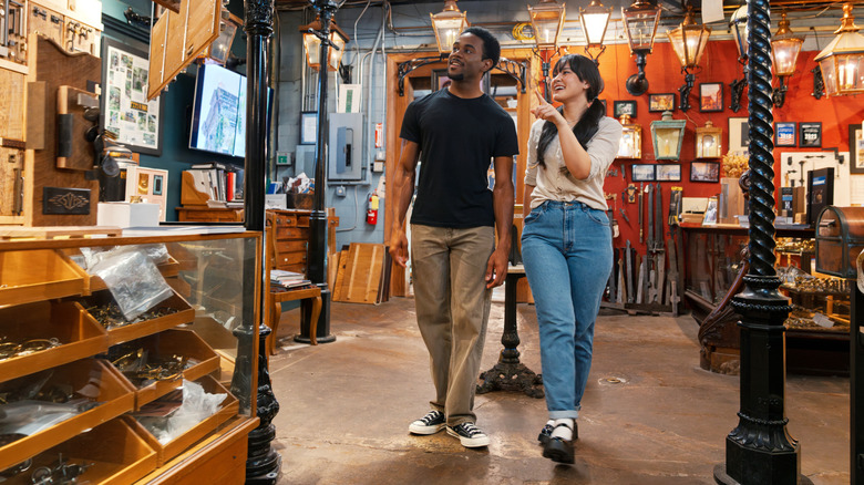 A young couple walks through a vintage shop