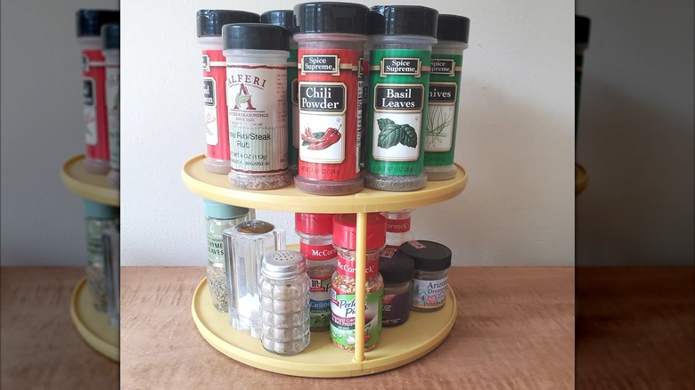 Yellow vintage lazy Susan used to hold spices on wood countertop
