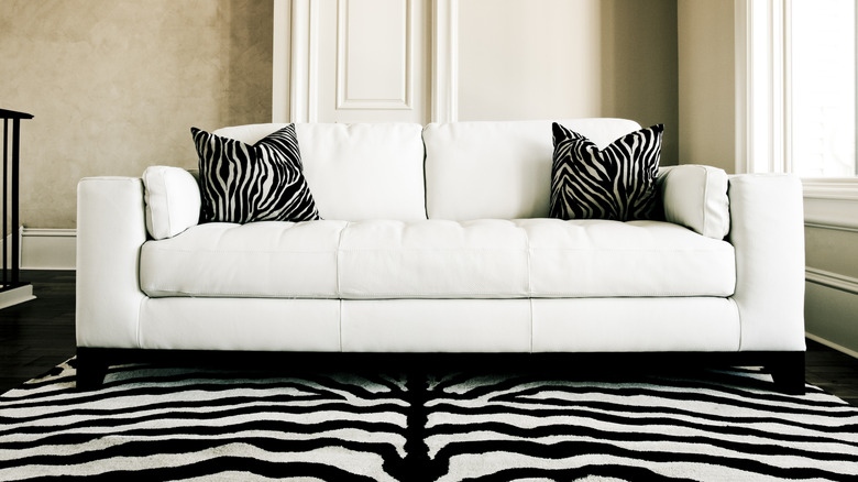 Zebra print rug under white couch