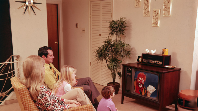 Couple sitting on a couch in a brightly colored retro-style living room