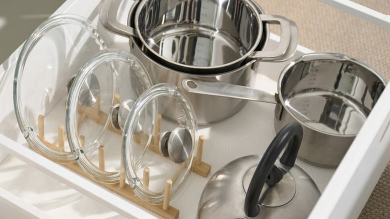 Row of sorted pot lids on an IKEA OSTBIT in a drawer