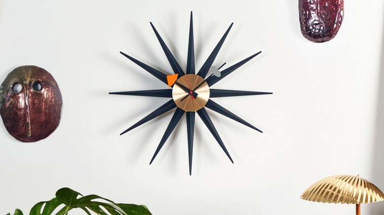 Black and gold mid-century modern starburst clock on wall