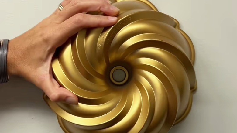 Man hanging Bundt pan on wall