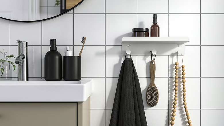 A white shelf with hooks hangs next to a bathroom sink