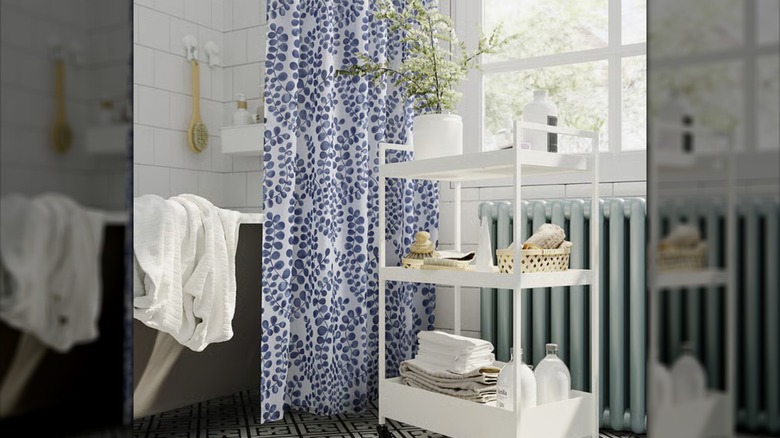 A blue and white shower curtain hangs in a light-filled bathroom