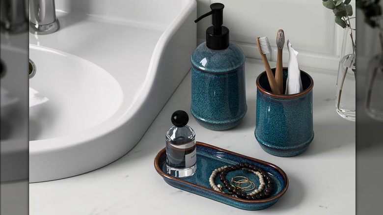 A set of blue ceramic containers are arranged on a white bathroom countertop